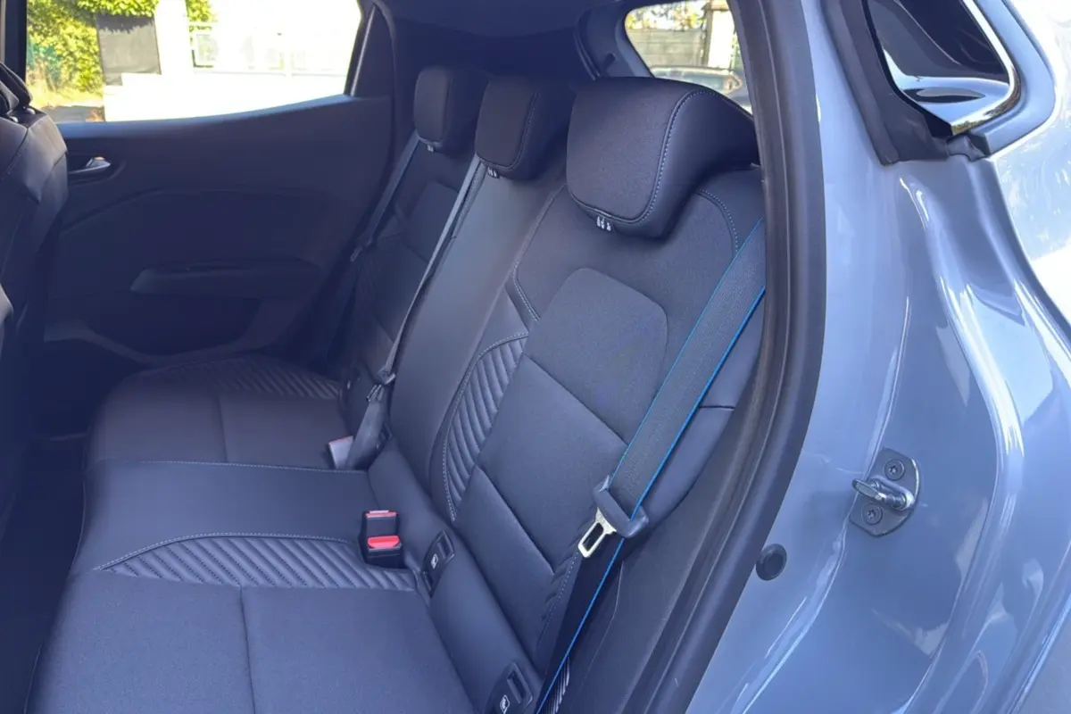Vue intérieure côté droit des sièges arrière noirs avec surpiqûres bleues dans une Renault Clio Gris rafale 2025 Esprit Alpine.
