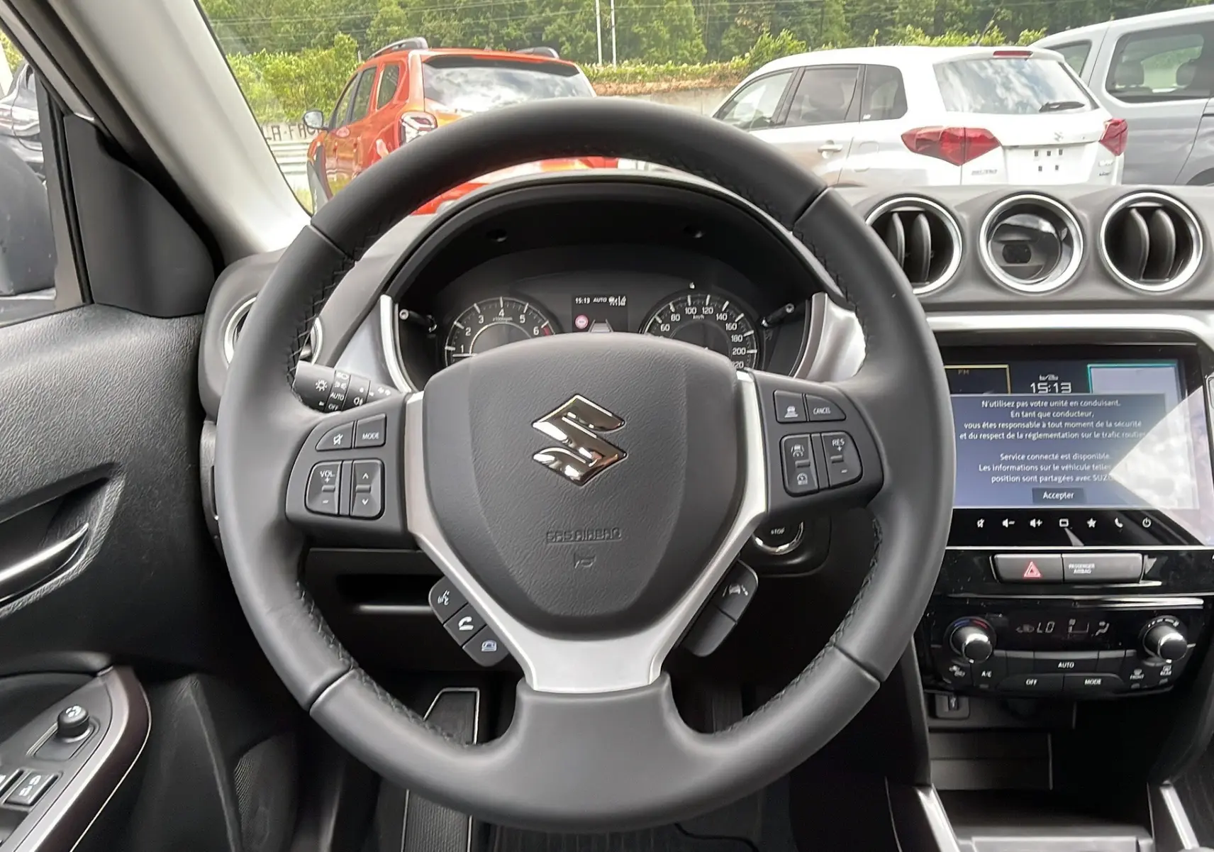 Vue intérieure centrée sur le volant cuir multifonctions du Suzuki Vitara 2025 avec écran tactile et commandes au volant.