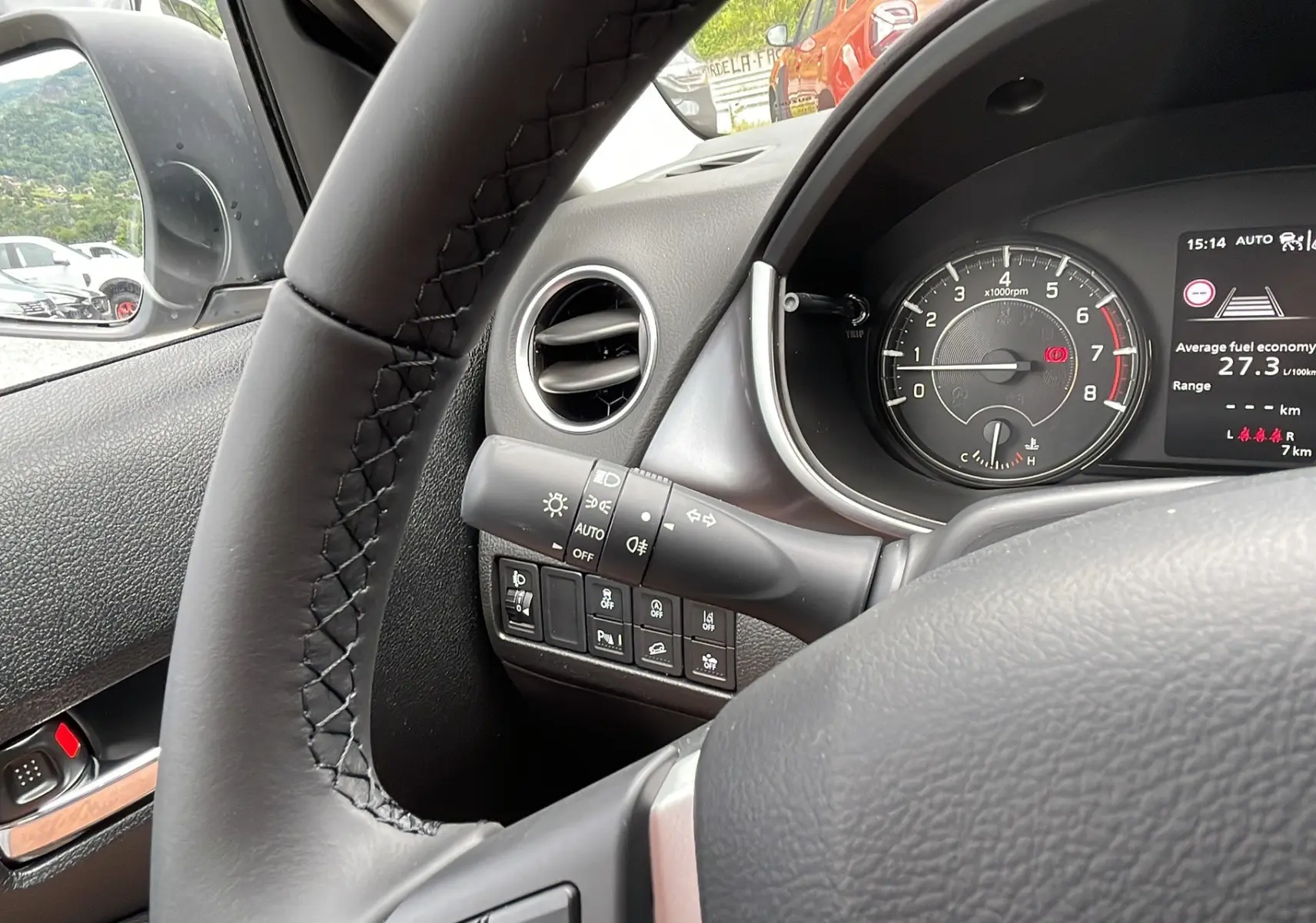 Vue intérieure côté conducteur du Suzuki Vitara 2025 en gris, volant cuir et tableau de bord avec compte-tours et écran multifonction.