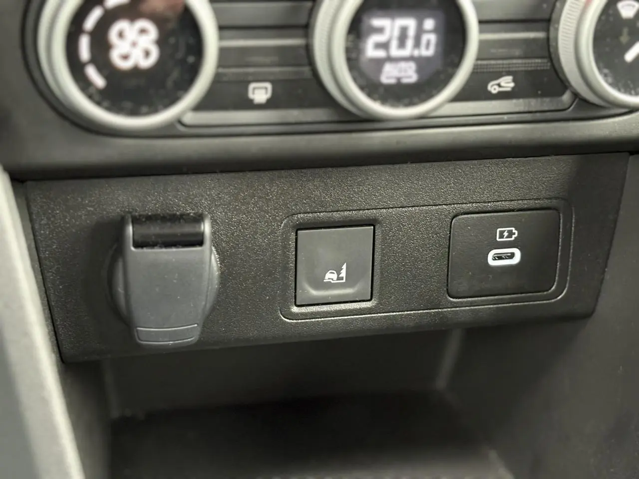 Gros plan sur les commandes du tableau de bord de la Dacia Sandero Stepway Bleu Iron, avec bouton d'aide au démarrage en côte et prise USB-C.