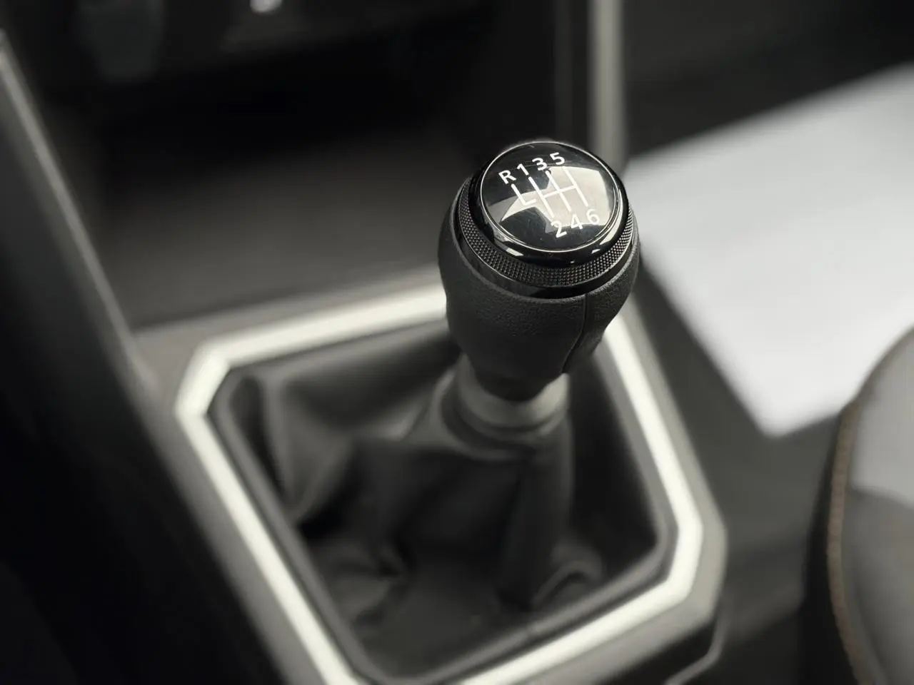 Gros plan sur le levier de vitesses manuel noir de la Dacia Sandero Stepway 2025, intérieur gris et noir.