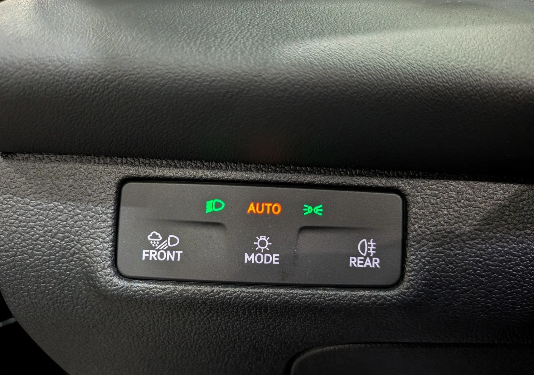 Panneau de commande des feux avec réglages automatiques et options frontales et arrière, intérieur noir du Volkswagen T-Roc.