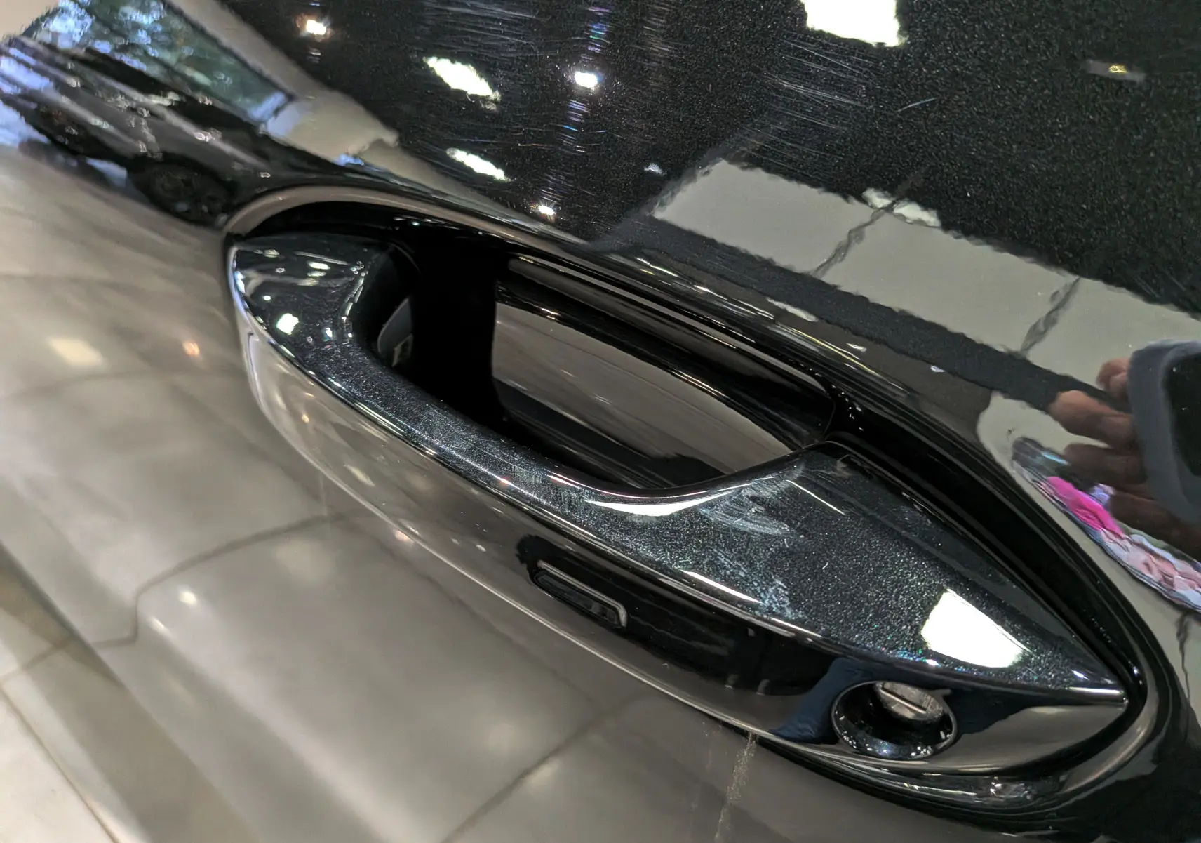 Gros plan sur la poignée de porte noire ébène du Volkswagen T-Roc eTSI 150 CH DSG7 R-Line 2026, finition brillante.