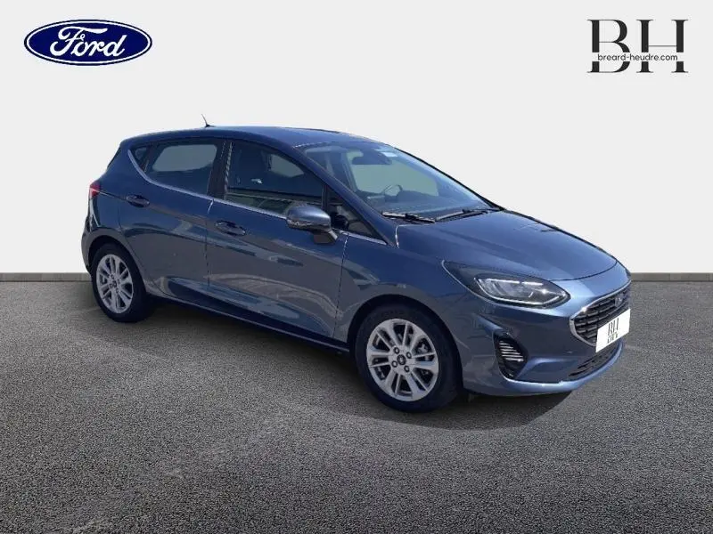 Ford Fiesta 2022 bleu azur métallisé vue 3/4 avant droit avec calandre chromée et jantes alu 16 pouces