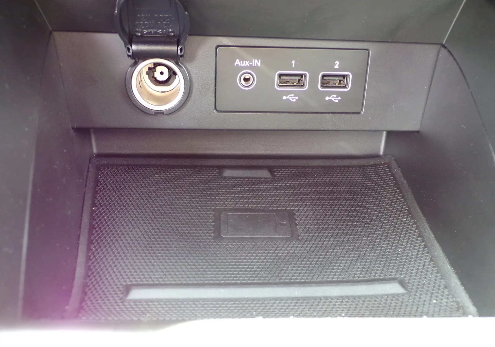 Gros plan sur la console centrale de la Renault Clio V 1.3 TCE 140 ch avec ports USB, prise Aux-IN et allume-cigare.