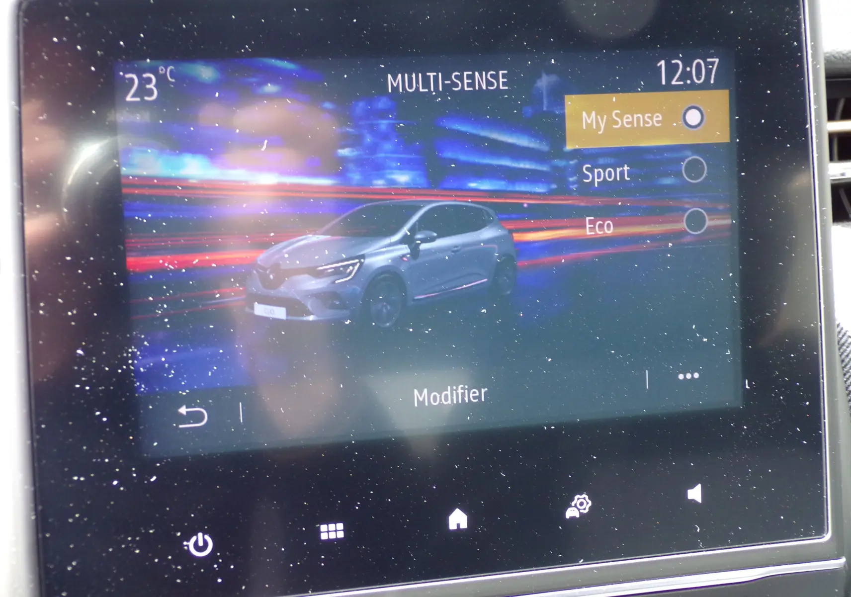 Écran tactile montrant une Renault Clio V blanche en 3/4 avant avec options de mode de conduite Multi-Sense.