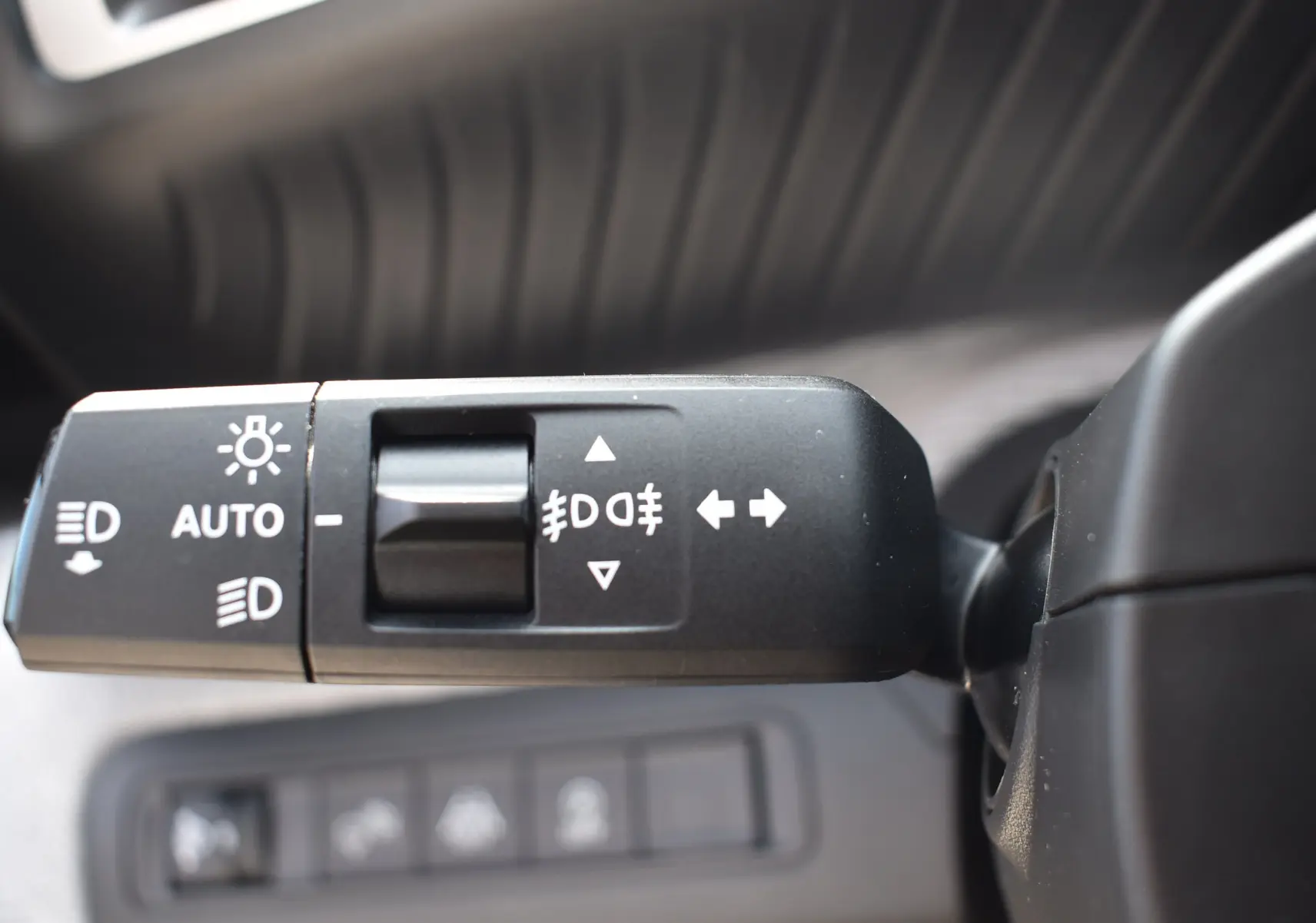 Gros plan sur la commande des feux et clignotants à gauche du volant dans une Citroën C3 bleu toit noir 2025.