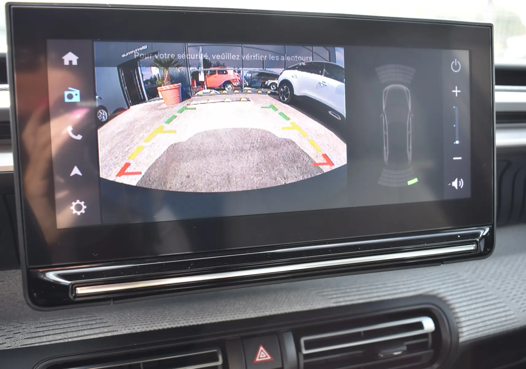 Écran central affichant la caméra de recul d'une Citroën C3 2025 bleu toit noir, vue arrière avec guidage coloré.