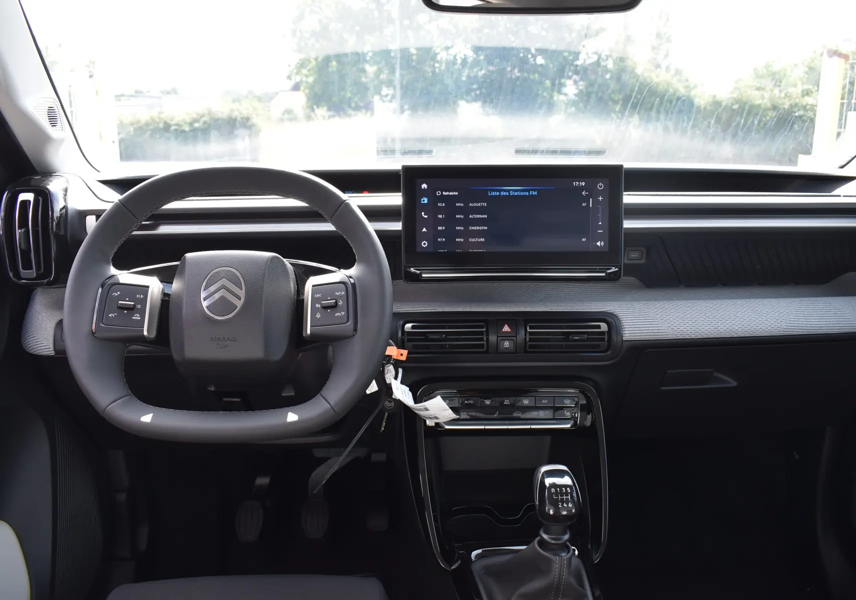 Intérieur de la Citroën C3 2025 bleu toit noir, vue frontale du tableau de bord avec volant et écran tactile central.