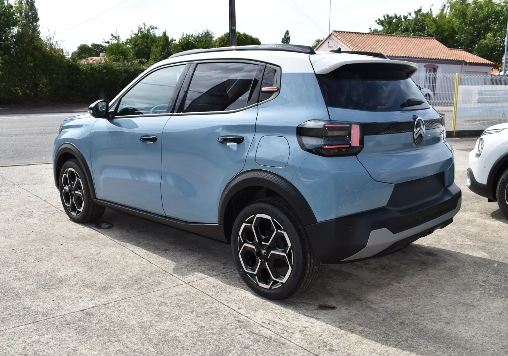 Vue 3/4 arrière gauche d'une Citroën C3 2025 bleu clair avec toit noir et jantes bi-ton noires.