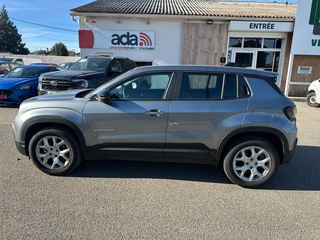 Vue de profil côté gauche d'un Jeep Avenger gris 2025 avec jantes alliage 17 pouces et toit noir contrasté.