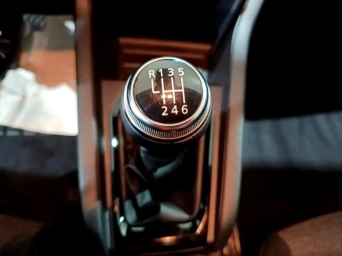 Le levier de vitesses manuel noir de la Renault Clio gris clair, vue en gros plan depuis l'intérieur central.