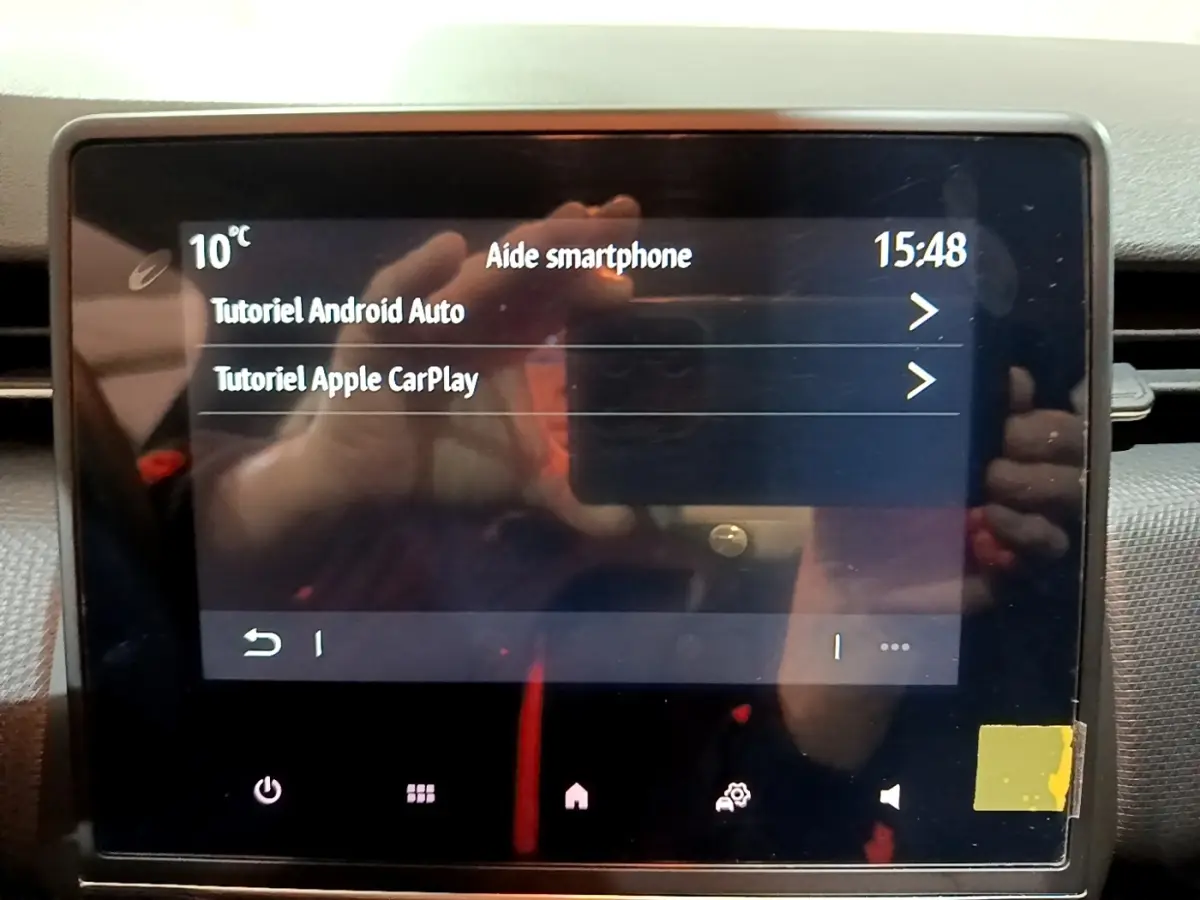 Écran tactile central de la Renault Clio gris clair 2023 affichant les tutoriels Android Auto et Apple CarPlay.
