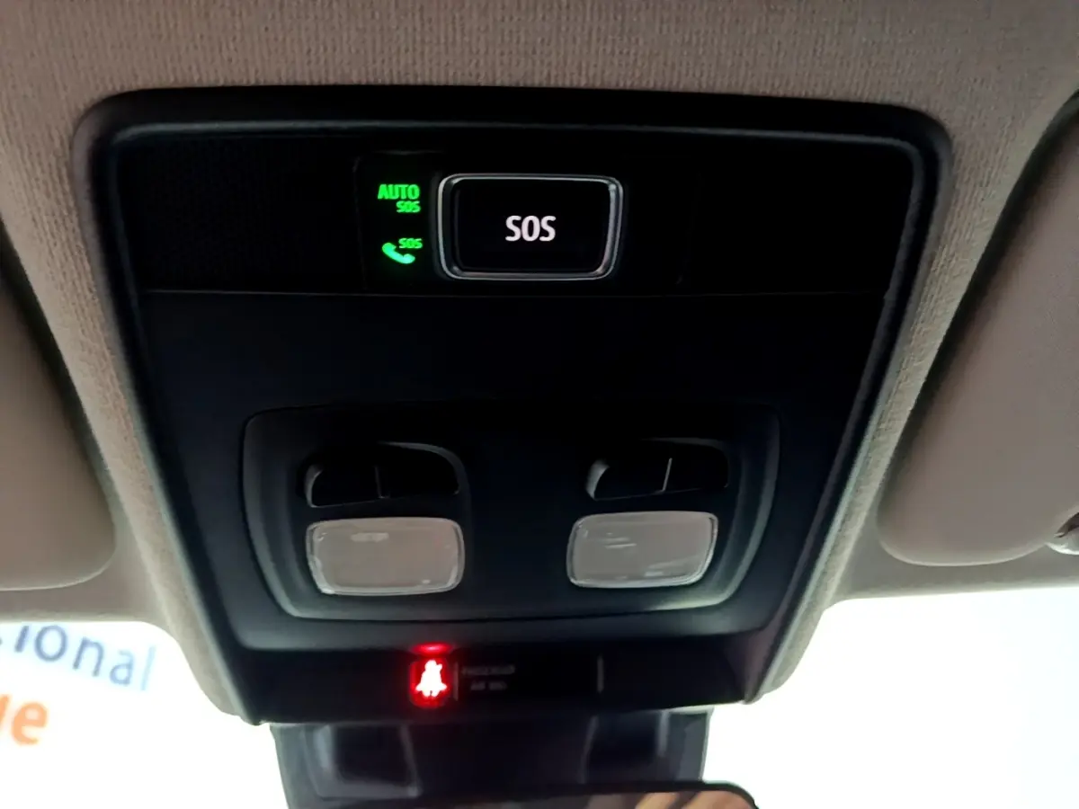 Vue intérieure en plongée sur le panneau de commande au plafond avec bouton SOS et éclairages dans une Renault Clio gris clair.