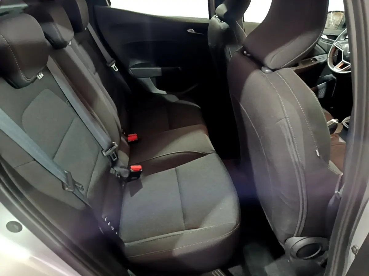 Vue intérieure côté droit montrant les sièges arrière noirs et partie avant d'une Renault Clio gris clair 2023.