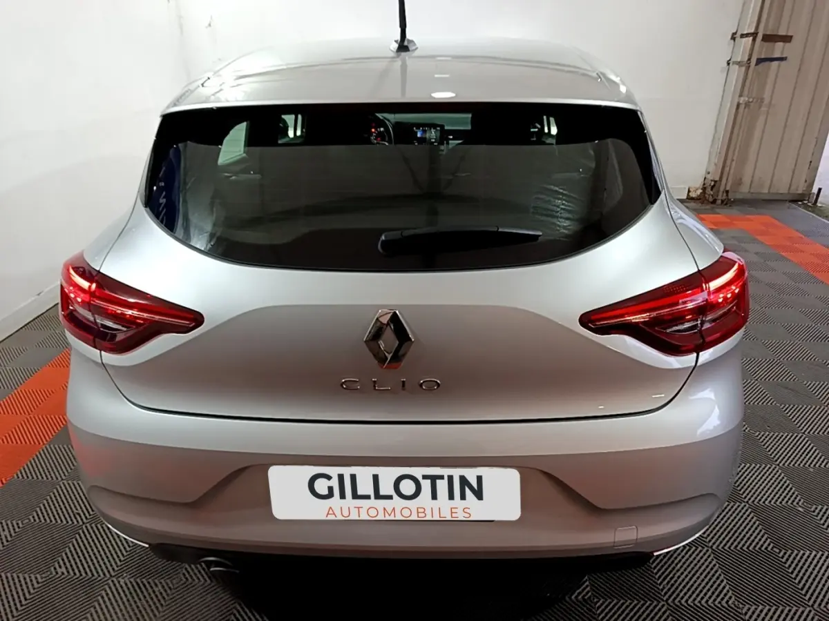 Vue arrière d'une Renault Clio gris clair 2023 avec feux LED et logo Renault bien visibles.