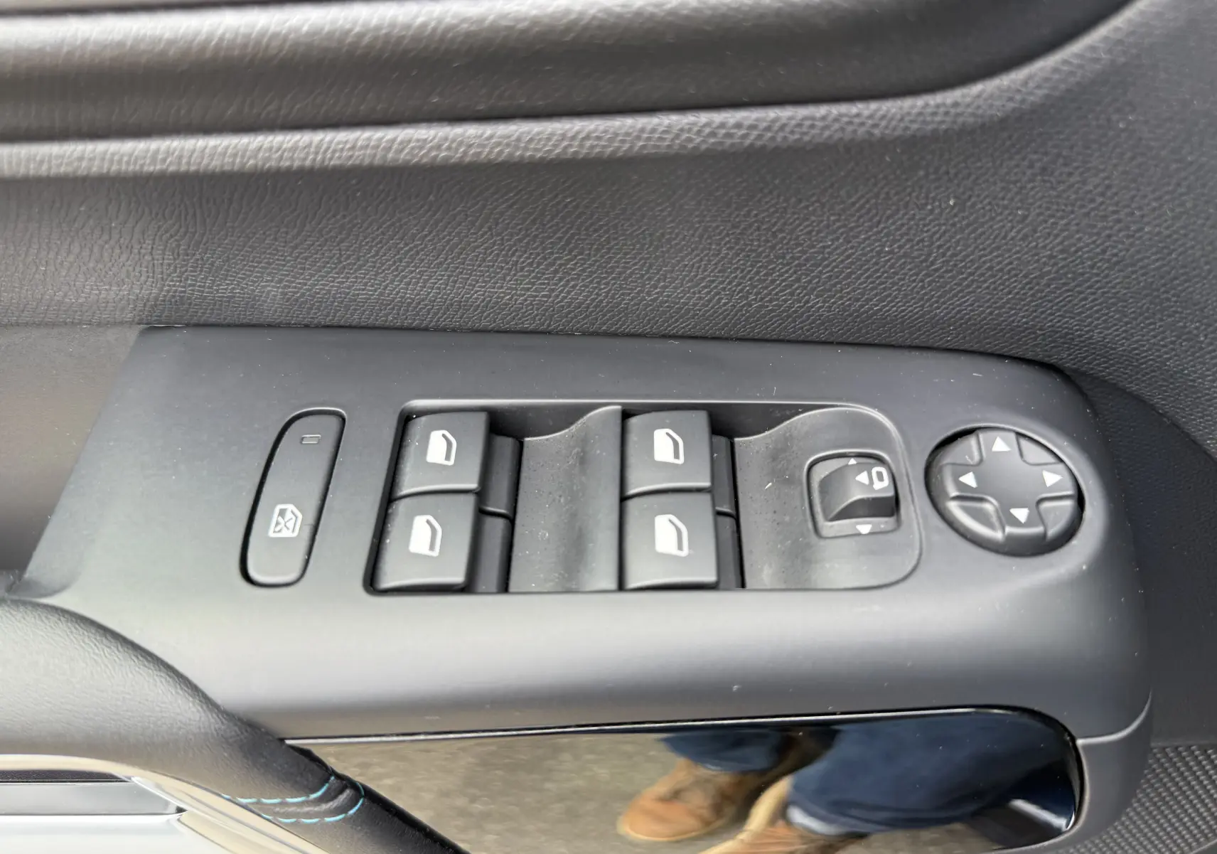 Gros plan sur les commandes de lève-vitres et rétroviseurs côté gauche intérieur du Citroën C5 Aircross Hybrid bleu foncé 2025.