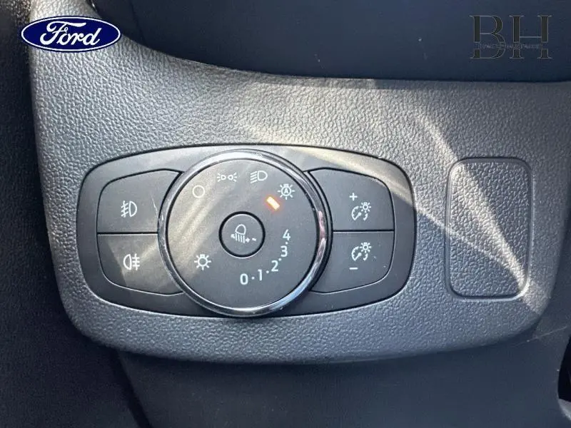 Gros plan sur le panneau de commande des phares du Ford Puma 2024 en tissu noir Kasbah, avec réglage d'intensité éclairage.