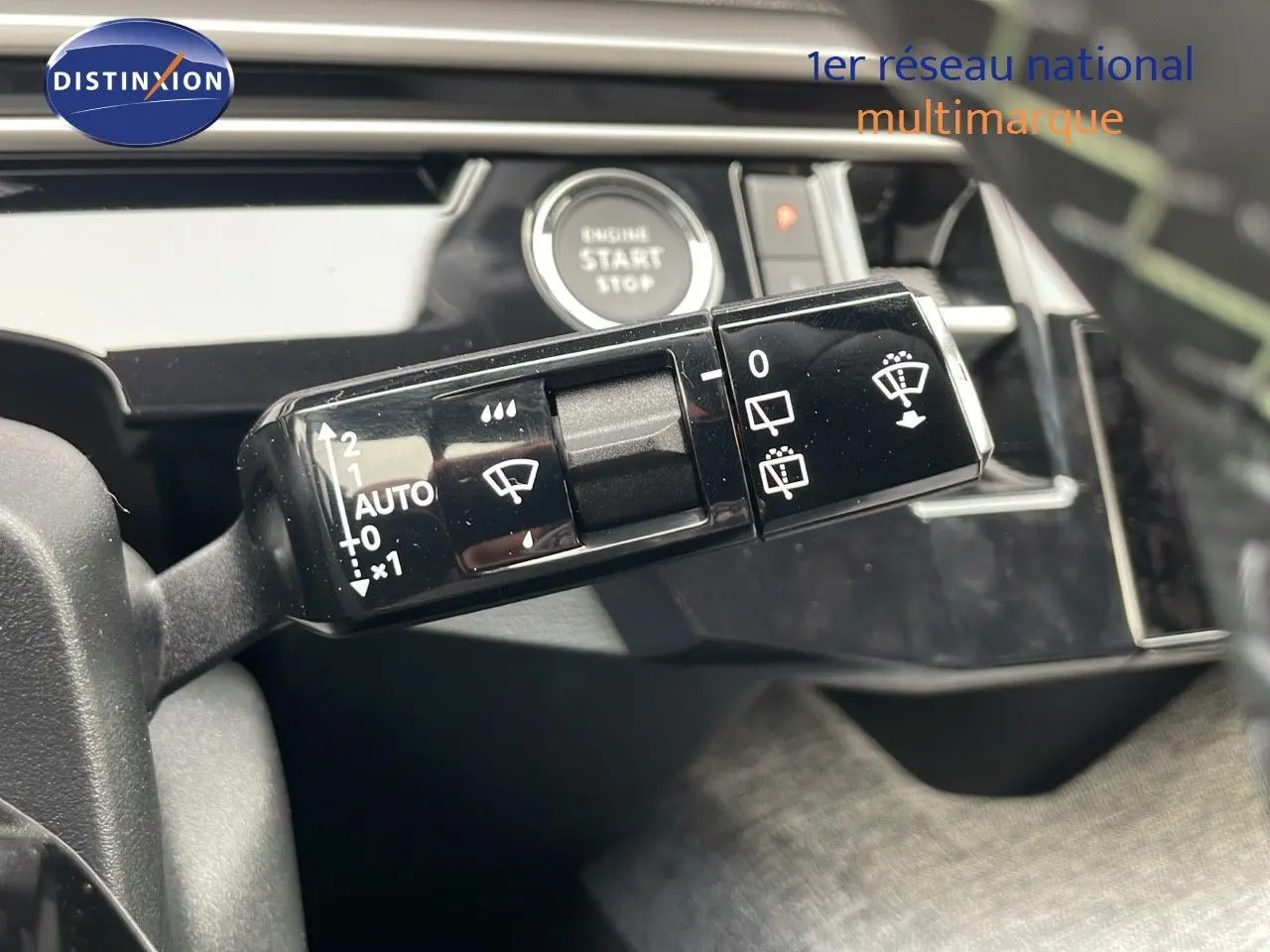Gros plan sur la commande des essuie-glaces du Peugeot 5008 hybride 2025, avec bouton start visible en arrière-plan.