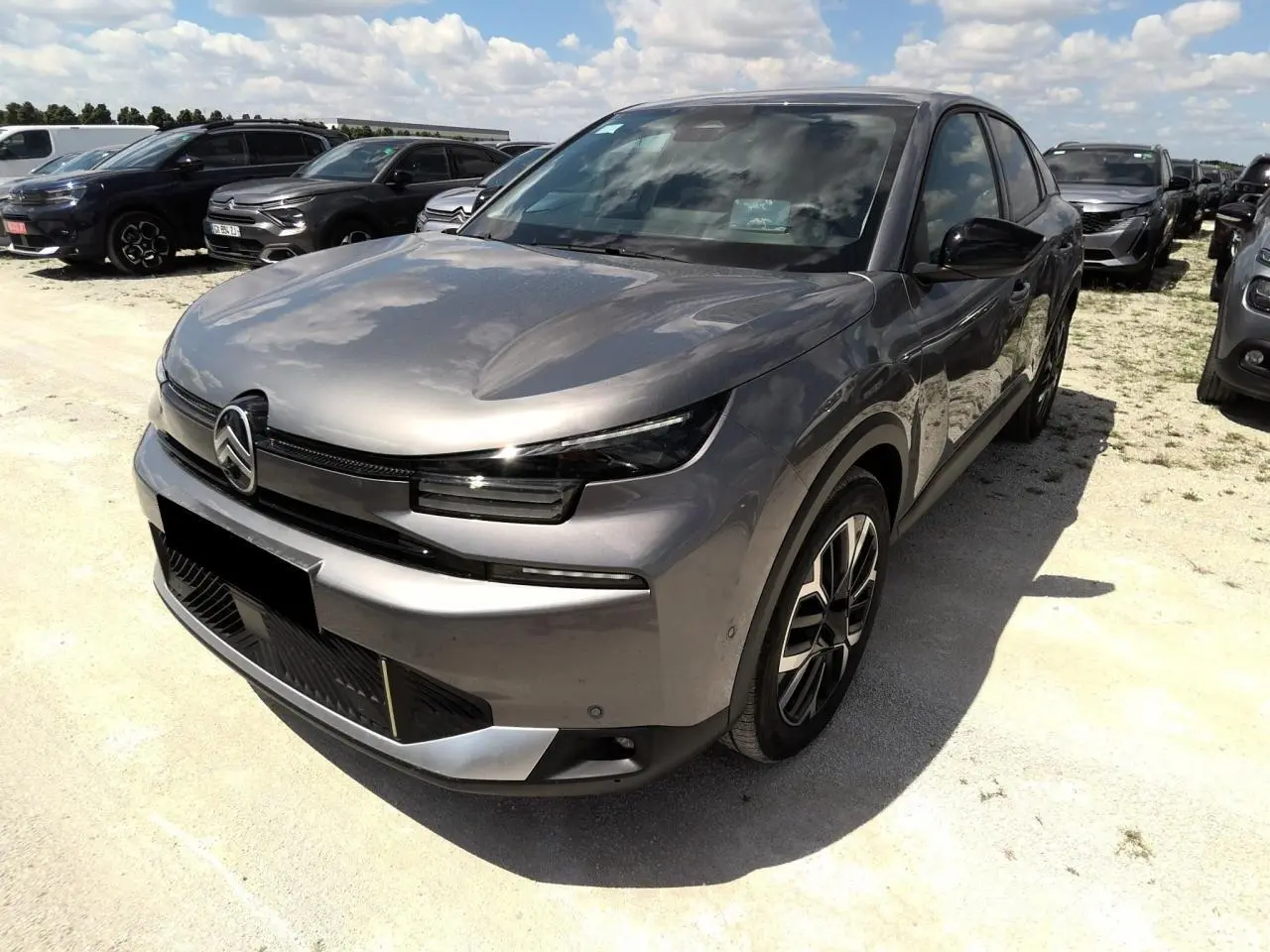 Citroën C4 Hybrid gris Mercury vue 3/4 avant droit, avec jantes alliage et phares LED distinctifs.