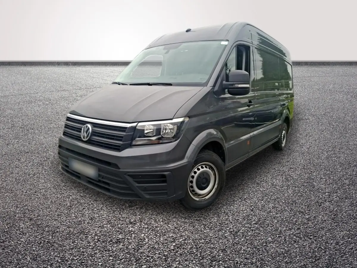 Volkswagen Crafter fourgon gris foncé vu en 3/4 avant droit sur sol gravillonné, avec jantes acier.