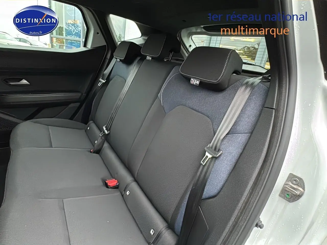 Vue côté droit de la banquette arrière noire et grise du Dacia Duster blanc Arctic 2025 avec ceinture de sécurité visible.