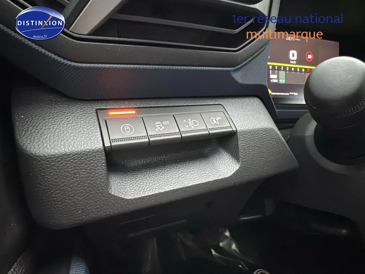 Gros plan sur les commandes de sécurité et d'assistance du tableau de bord du Dacia Duster 2025, intérieur noir.