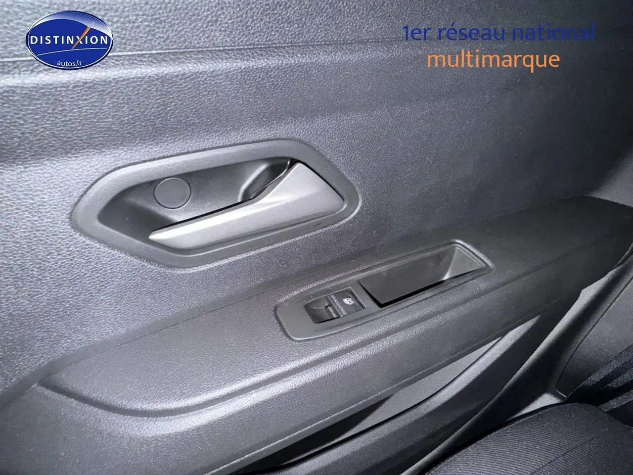 Poignée intérieure et commandes de vitre côté droit du Dacia Duster blanc Arctic 2025, version 1.2 TCe mild hybrid.