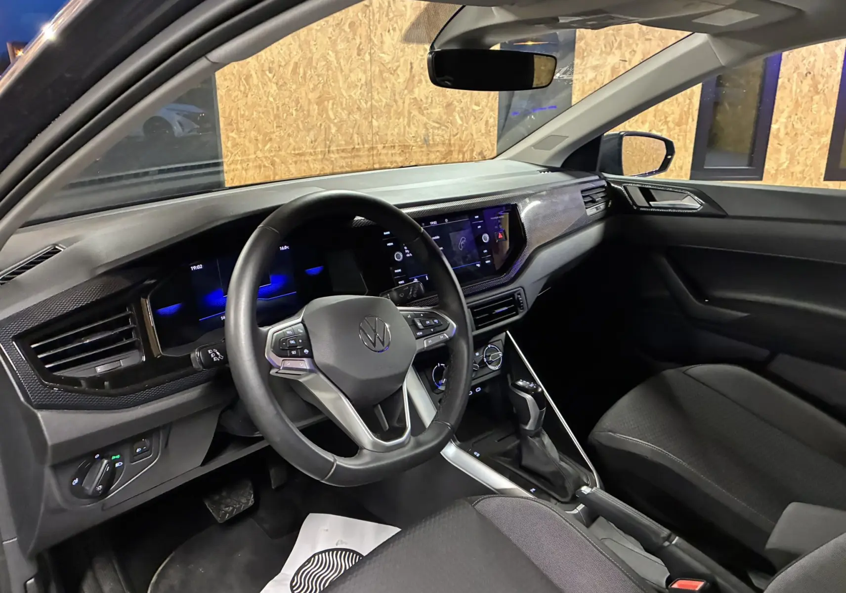 Vue intérieure côté conducteur de la Volkswagen Polo gris 2025, tableau de bord moderne avec écran tactile et volant multifonction.