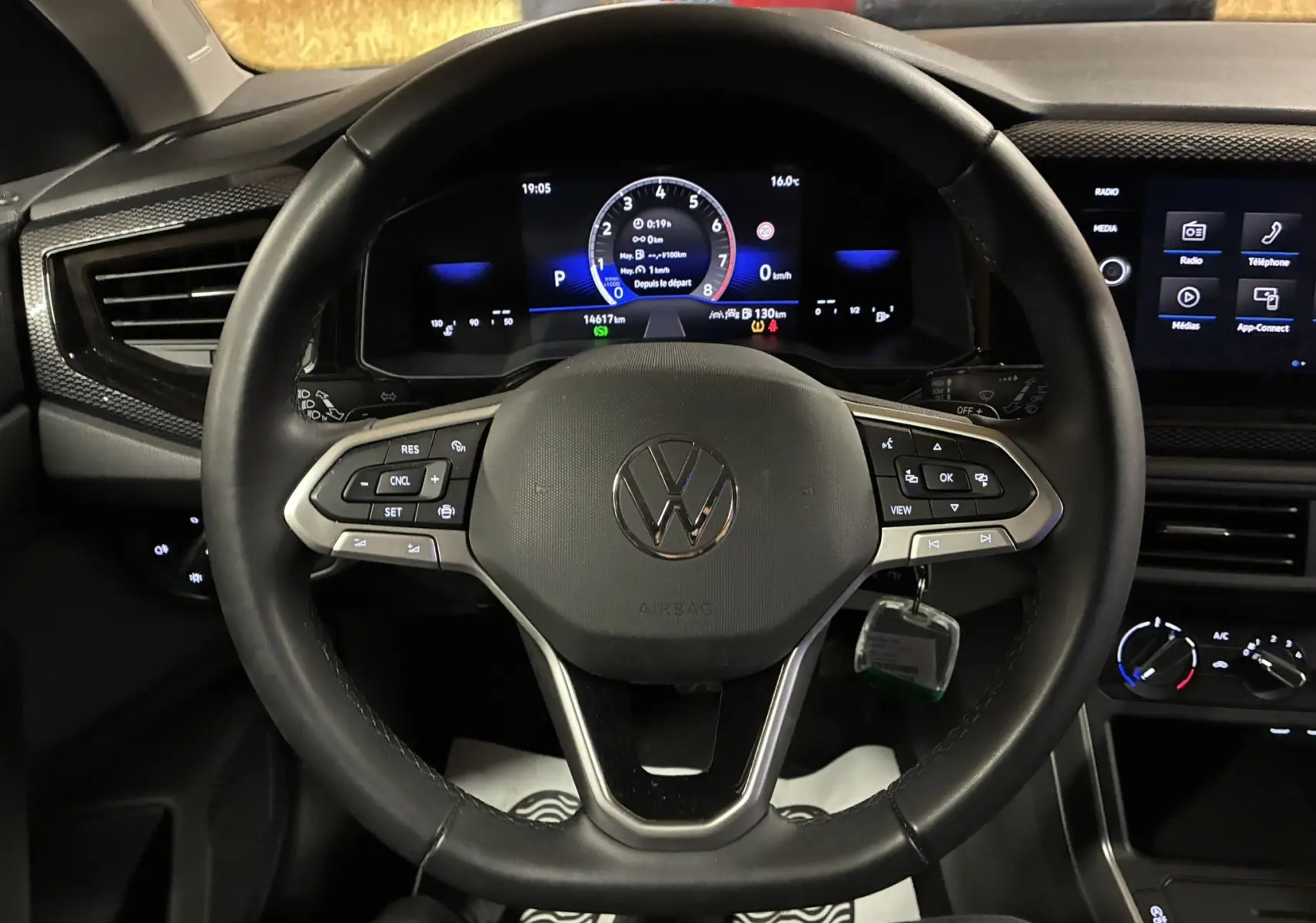 Vue rapprochée du volant noir de la Volkswagen Polo 2025 avec tableau de bord numérique et écran tactile central.