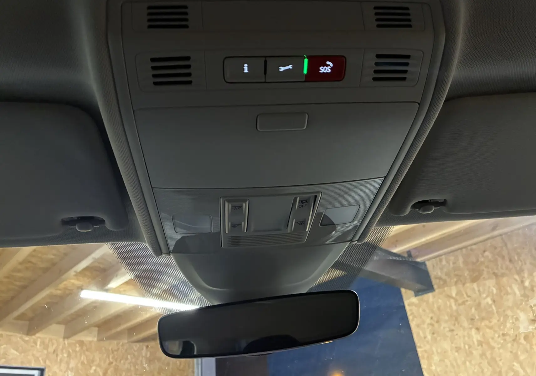 Vue intérieure du toit avec commandes d'éclairage et bouton SOS au-dessus du rétroviseur d'une Volkswagen Polo grise 2025