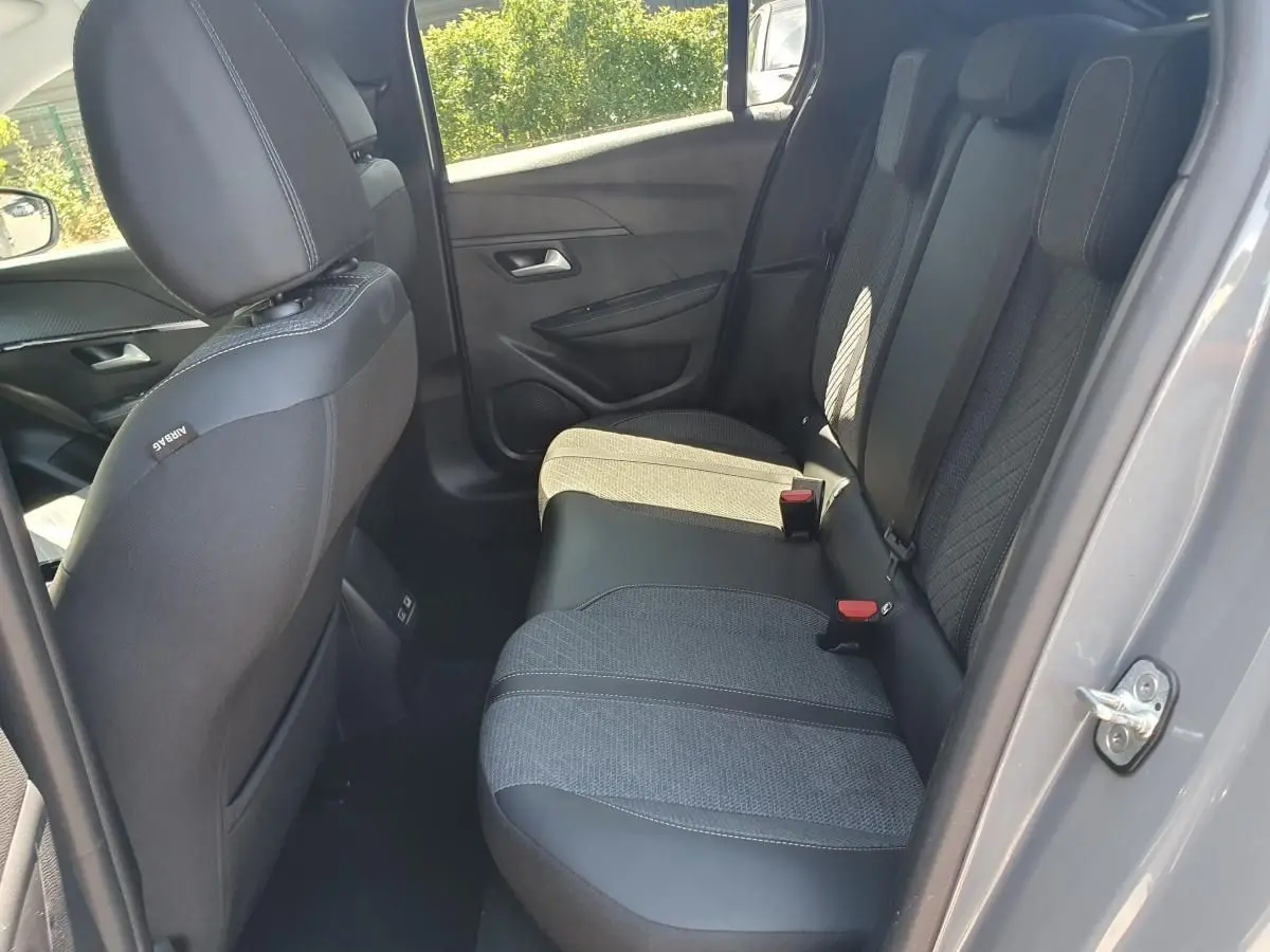 Vue intérieure côté droit sur la banquette arrière en tissu et cuir noir de la Peugeot 208 gris Sellenium 2025.