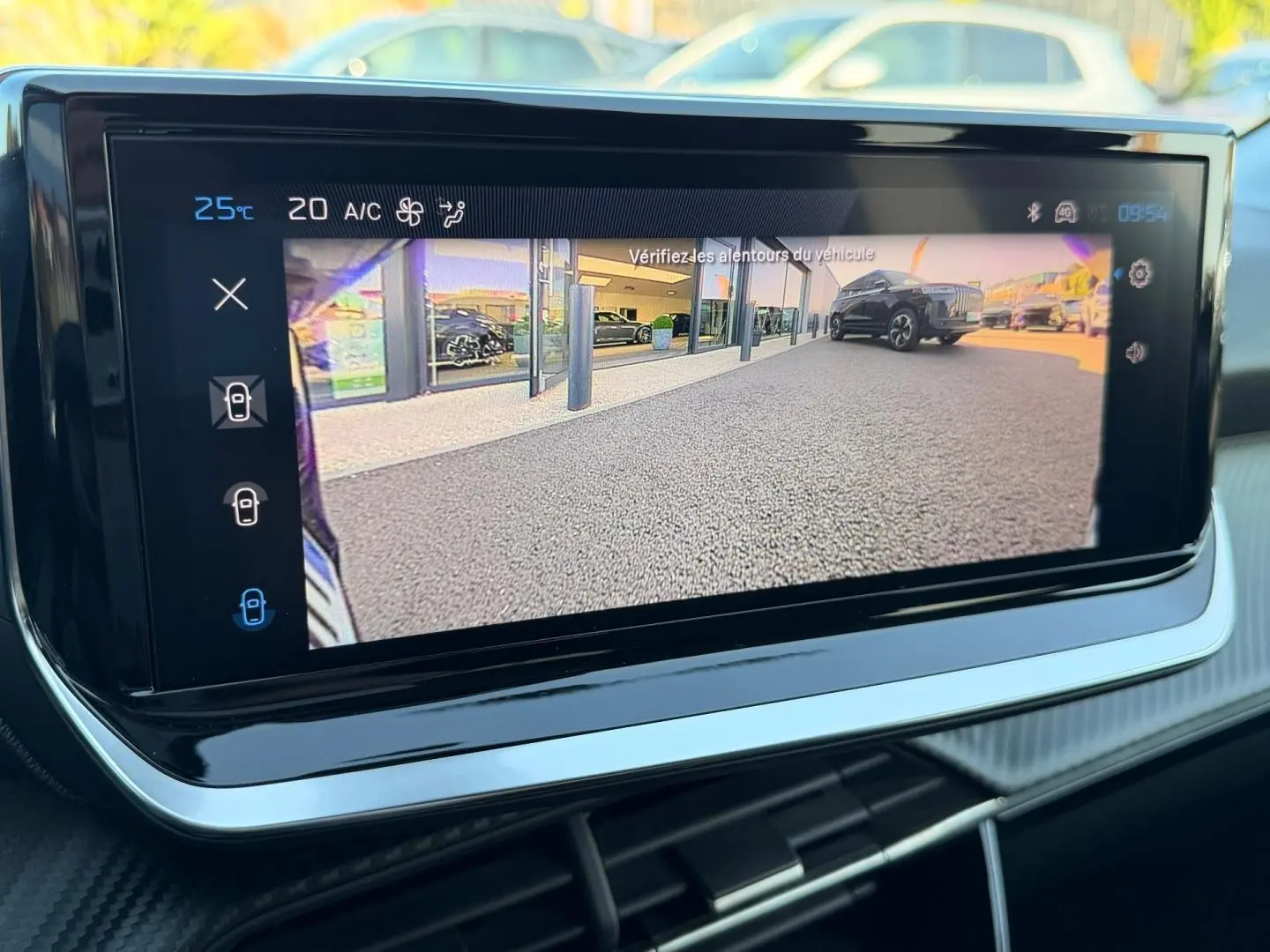 Écran tactile intérieur affichant la caméra de recul avec vue sur un SUV noir en arrière-plan.