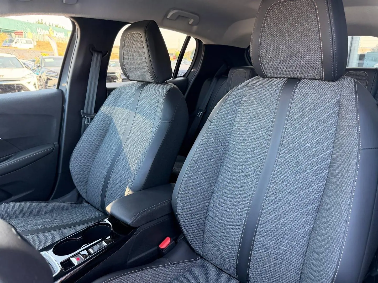 Vue intérieure rapprochée des sièges avant gris tissu et simili cuir de la Peugeot 208 1.2 100ch Allure.