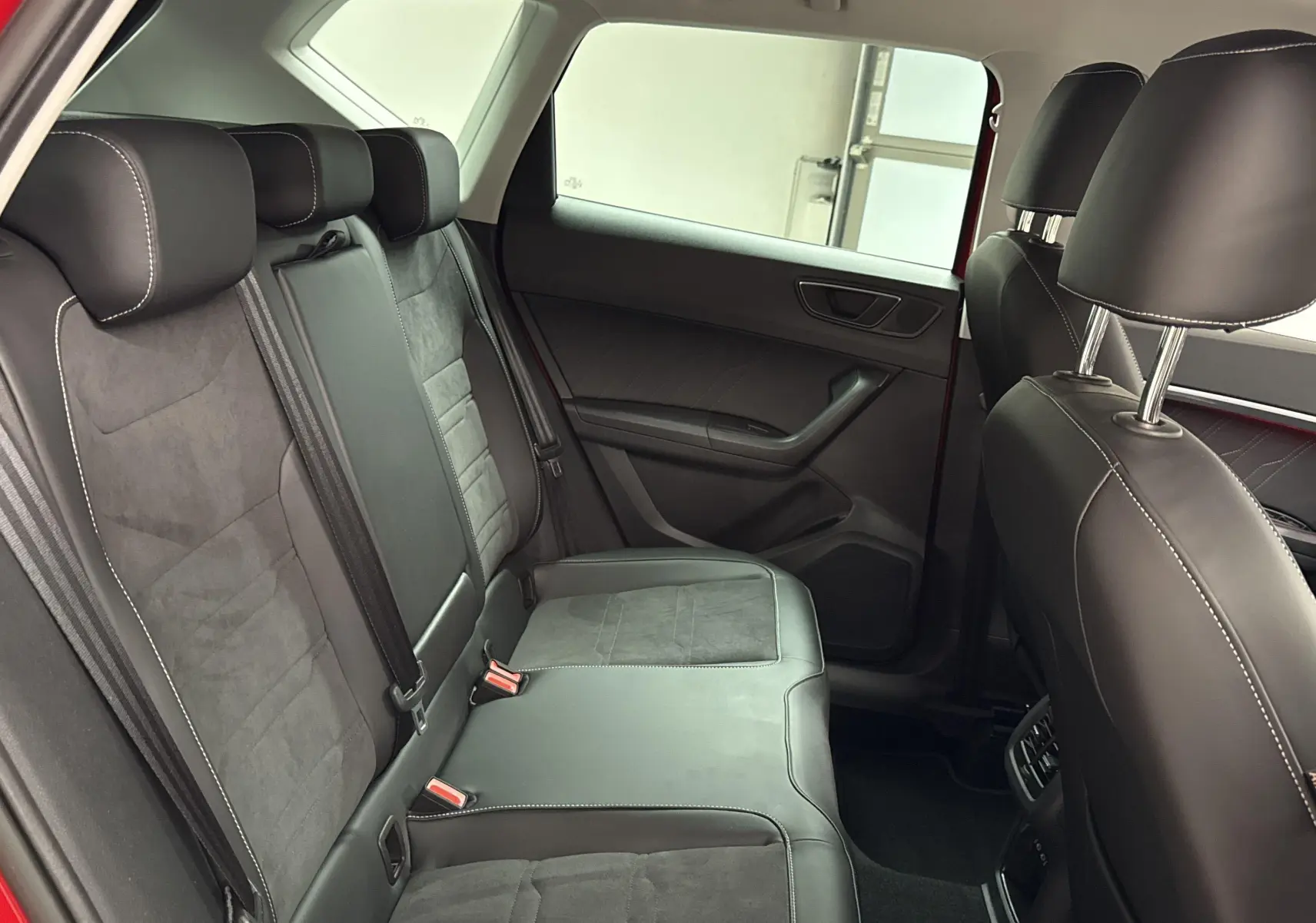 Vue intérieure côté gauche des sièges arrière en cuir noir avec surpiqûres blanches du SEAT Ateca Rouge Velvet 2024.