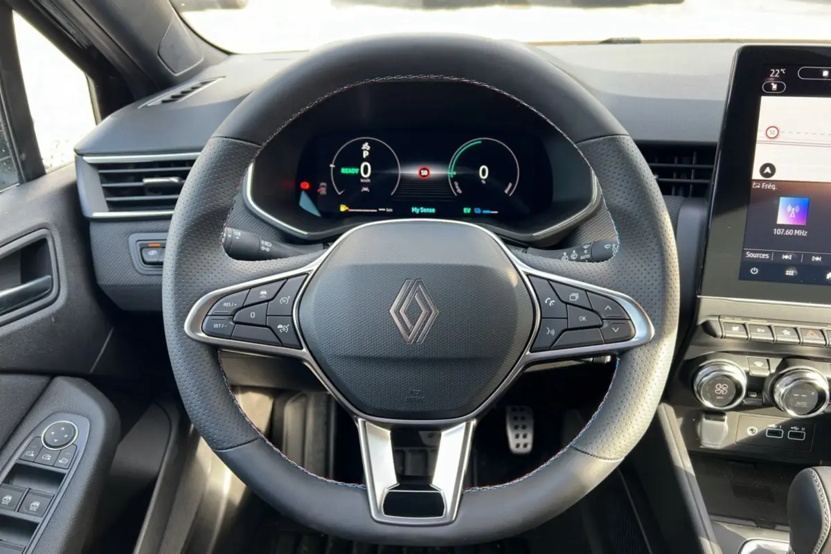 Vue rapprochée du volant et du tableau de bord numérique de la Renault Clio V E-TECH 145 Esprit Alpine 2025 en intérieur.
