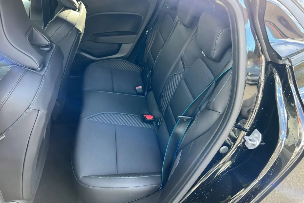 Intérieur arrière de la Renault Clio V E-Tech 145 Esprit Alpine 2025 en noir étoilé, vue côté droit avec sièges en tissu et cuir.