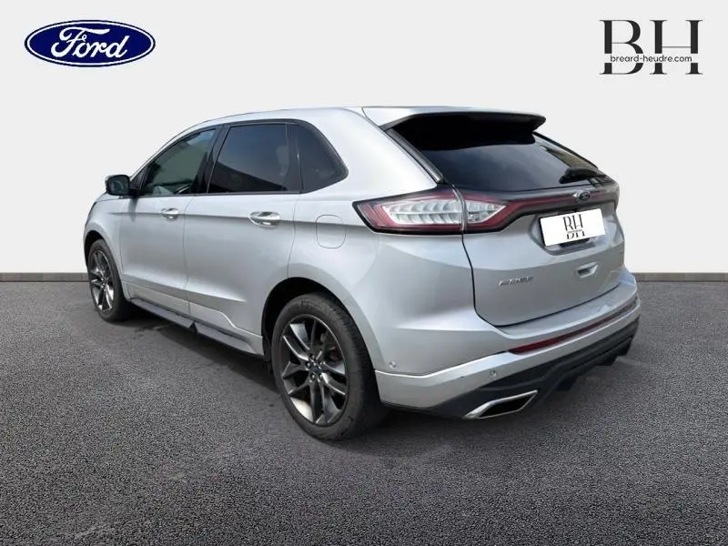 Vue 3/4 arrière droite d'un Ford Edge gris Ingot avec attelage et feux arrière LED distinctifs.