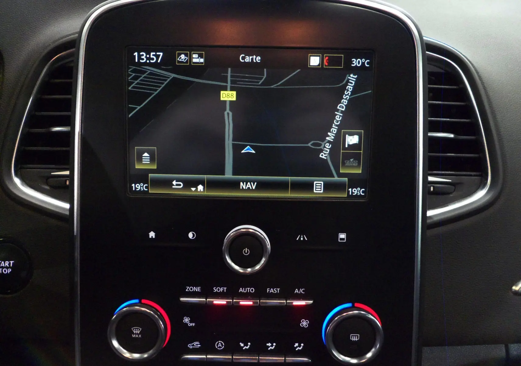 Écran tactile central avec navigation affichée et commandes de climatisation sur Renault Grand Scenic IV blanc Glacier, vue intérieure.