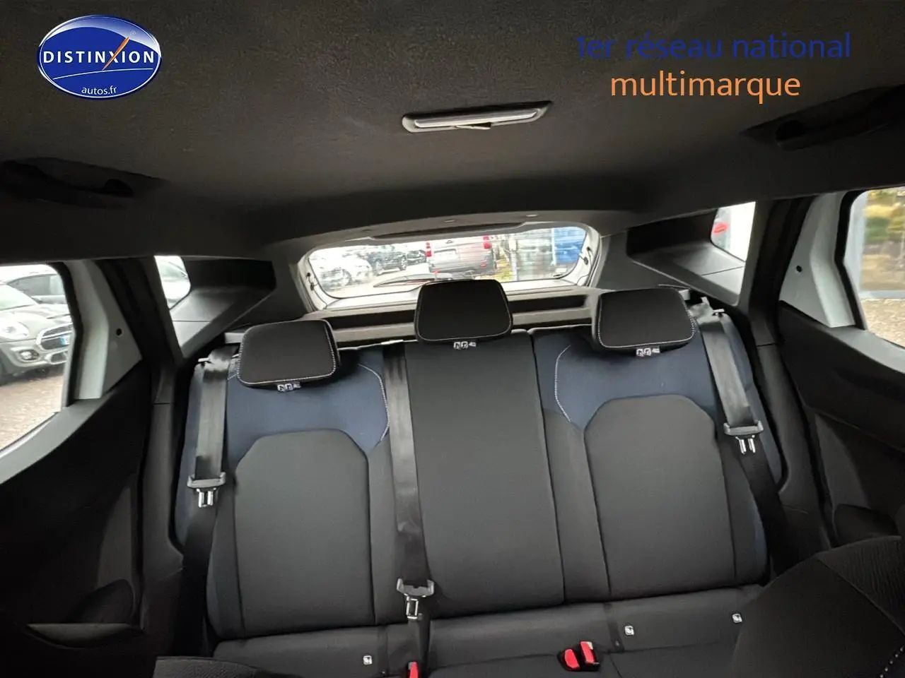 Banquette arrière noire et bleue vue de l'intérieur du Dacia Duster 2025 avec appuie-têtes et ceintures visibles.