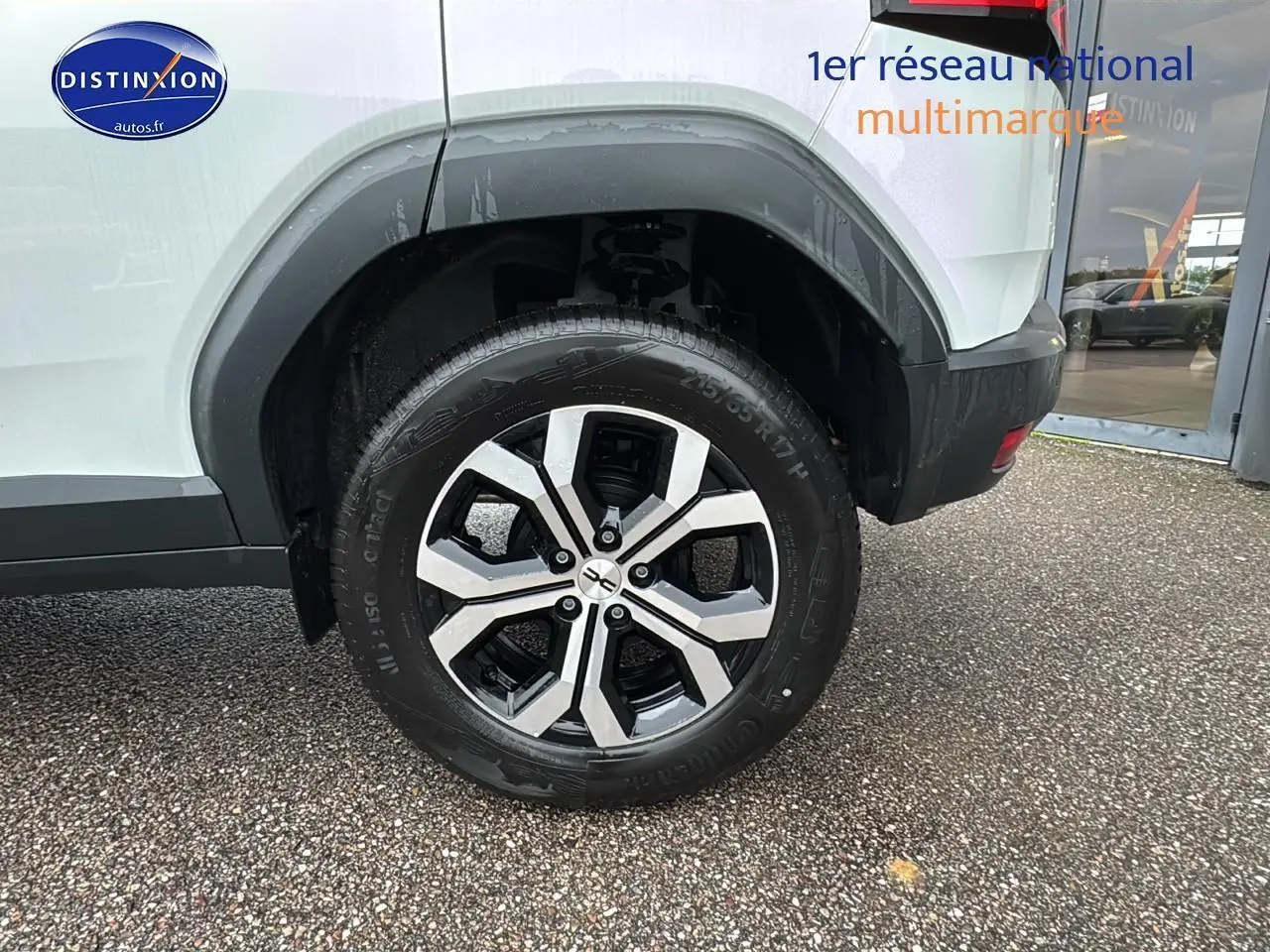 Gros plan sur la roue arrière droite du Dacia Duster blanc Arctic avec jante alu au design moderne.