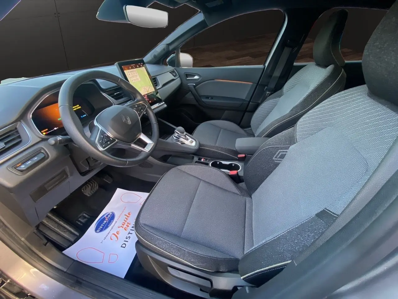 Vue intérieure côté conducteur de la Renault Symbioz E-Tech gris Casiopee, avec sellerie Techno et écran tactile vertical.