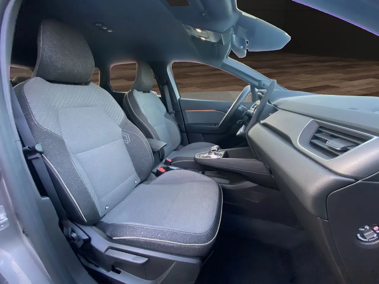 Vue intérieure côté gauche de la Renault Symbioz E-Tech gris Casiopee, avec sièges tissu Techno et tableau de bord moderne.