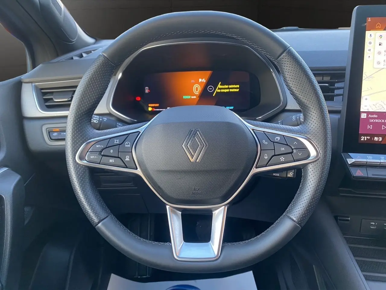 Vue centrée sur le volant noir perforé de la Renault Symbioz 2025 avec tableau de bord numérique et écran tactile latéral.