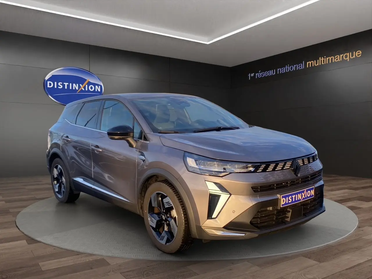 Renault Symbioz gris Casiopee en 3/4 avant droit, jantes alliage noires et calandre moderne avec logo Renault.