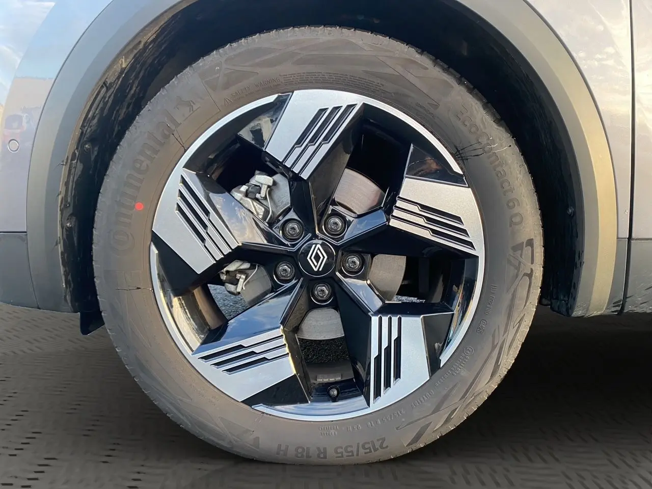 Gros plan sur la jante alliage 18'' diamantée noire et grise du côté gauche d'une Renault Symbioz gris Casiopee.