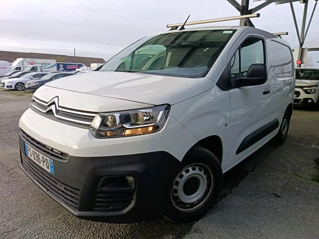 Vue 3/4 avant droit d’un Citroën Berlingo blanc 2020 avec calandre noire et barres de toit métalliques.
