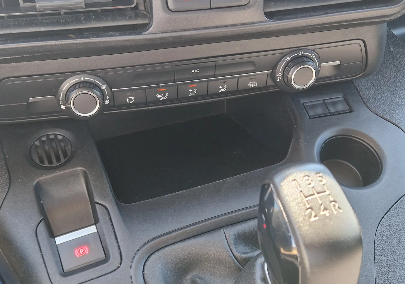 Vue rapprochée du tableau de bord du Citroën Berlingo blanc 2020, avec commandes climatisation et levier de vitesse manuel.