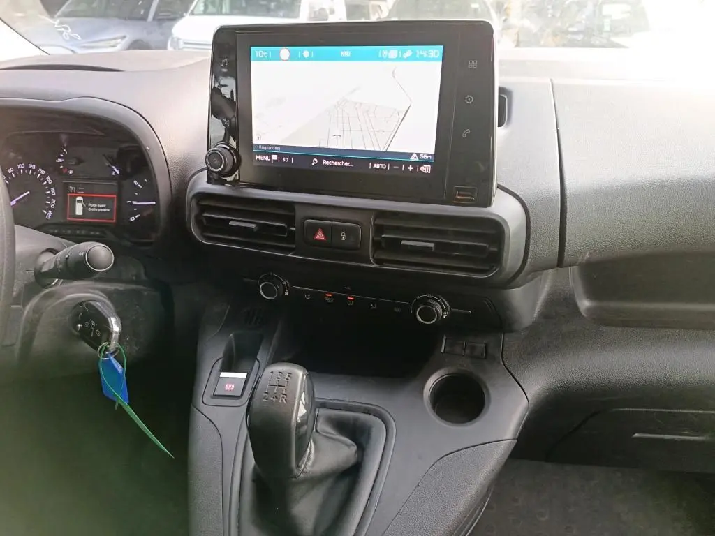 Vue intérieure du tableau de bord du Citroën Berlingo 2020 avec écran tactile, commandes de climatisation et levier de vitesse manuel.