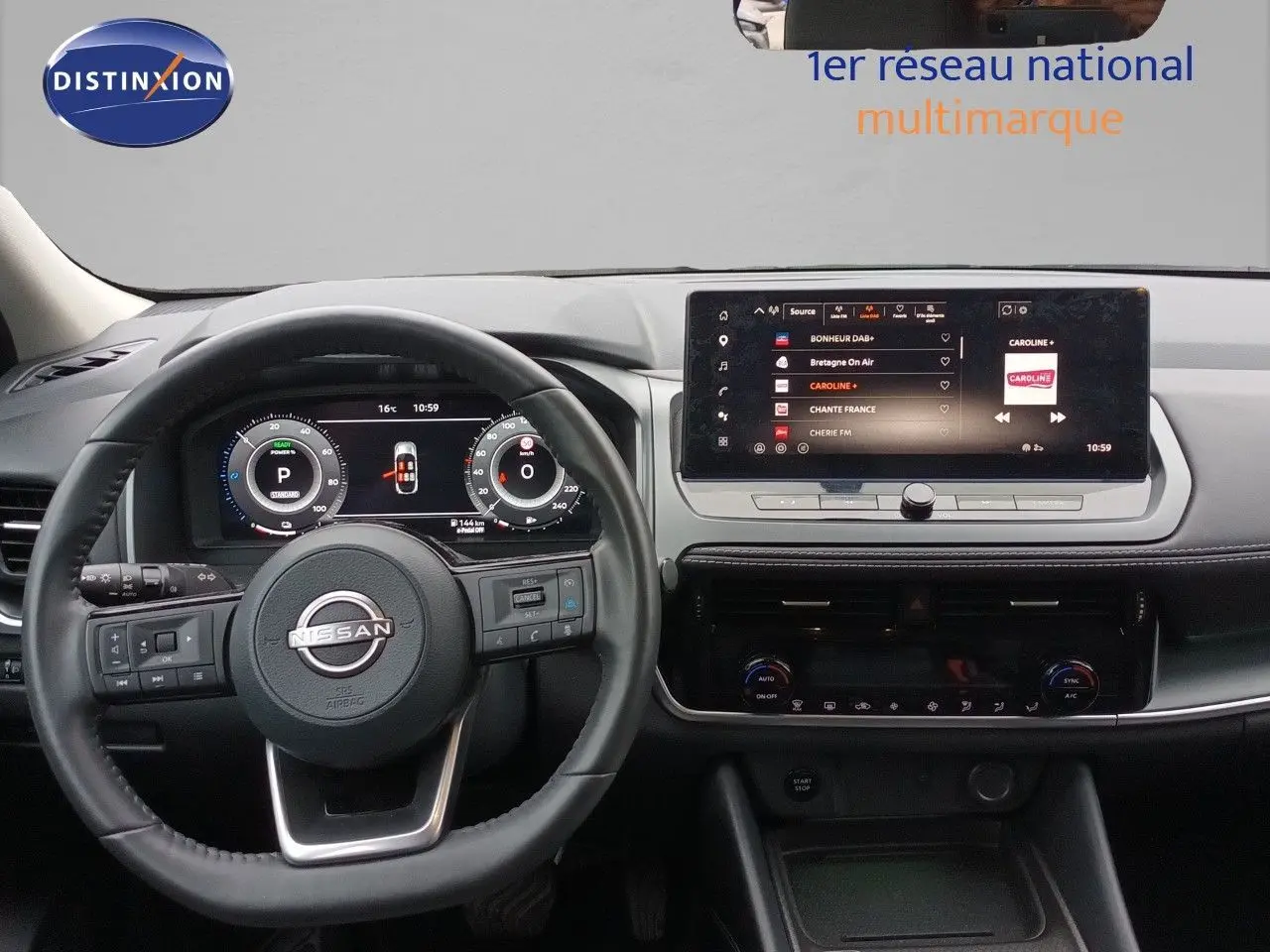 Vue intérieure centrée sur le tableau de bord et le volant du Nissan Qashqai noir avec écran tactile et commandes digitales.